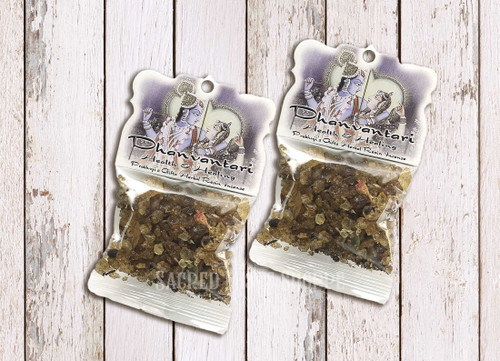 Two packages of Dhanvantari Health and Healing Resin Incense sample size packages on a light-colored distressed wood table.