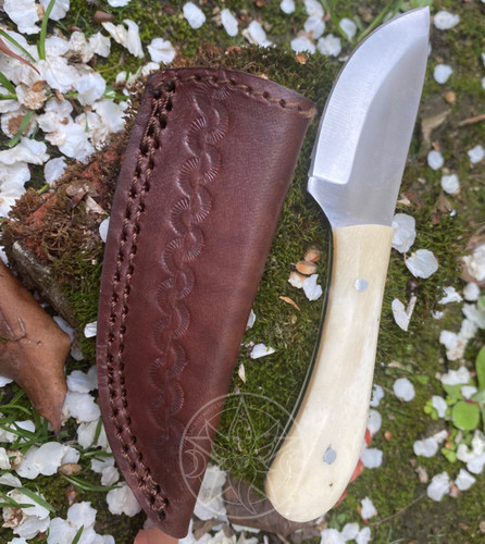 The Herbalist's Boline is crafted with a beautiful creamy bone handle and features a beautiful curved and sharpened blade, perfect for cutting herbs and other items used in herbalism recipes or for the witch's altar use. This beautiful and unique boline comes complete with a decorative sheath for blade protection and safe storage.