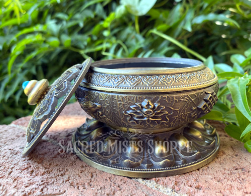 Tibetan Temple Bowl. Stunning patinaed brass is complemented with a splash of color on the lid of this beautiful Tibetan-style incense bowl. This bowl is not only substantially made but incredibly stylish to add an air of sophistication to any space.