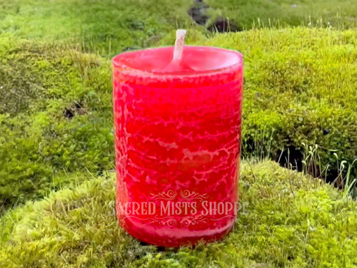 One Dragon's Blood Protection Votive Candle stands on moss covered bricks shown from the front