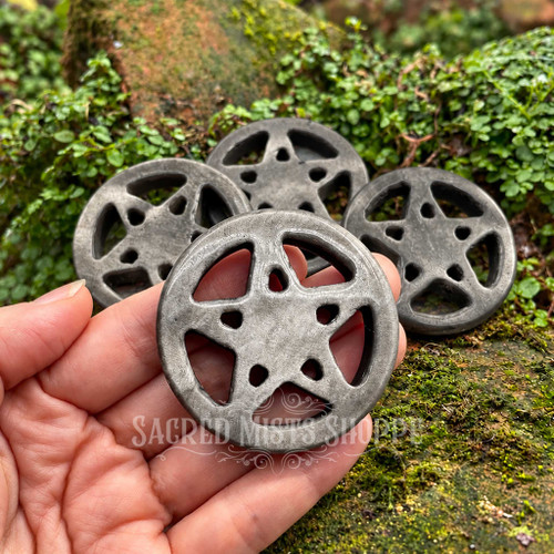 Silver Sheen Obsidian crystal pentacle altar tile held in hand, showing its carved openwork star and natural silvery gray sheen.