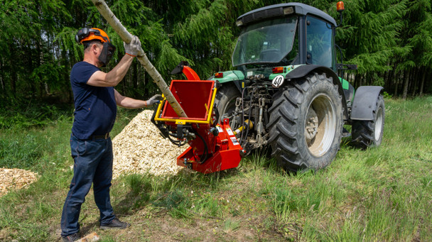 Remet RT-630R PTO Disc Chipper with tractor in use viewed from the right rear