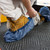 Premium Blue Shoe Covers Waterproof Anti-Skid, shown in use on a rug
