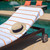 30x60 Las Rayas Resort Towels 4 Pack, shown on a lounge chair