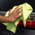 Yellow 16x16 SmartRags Mid-Weight Microfiber Towel Dispensing Box, shown wiping the taillight of a car