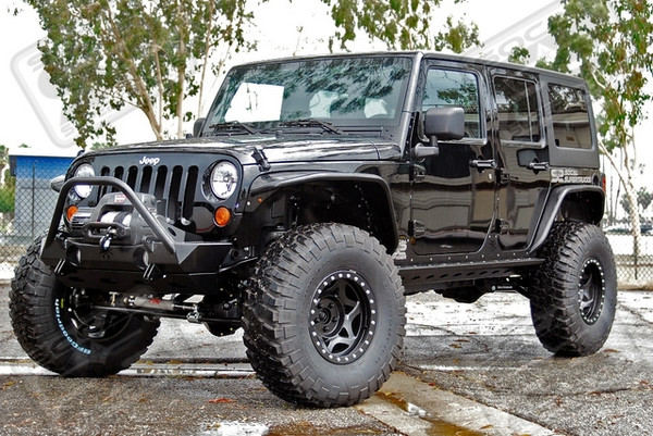This 2011 Unlimited Rubicon JK, Dubbed the "SoCal Spyder" Sports A Rock Krawler 5.5" Triple Threat Long Arm Suspension System With 3.5" Coils and Bilstein 5100 Series Shocks. Body Armor All the Way Around the Jeep was Provided by Poison Spyder Customs, and Includes Aluminum Fender Flares, Front and Rear Bumpers, Rock Sliders, an EVAP System Skidplate, and Front and Rear Differential Covers. Walker Evans Racing 17" Beadlocks Were Mounted Up With 37x12.50x17 BF Goodrich KM2 M/T Tires. Other Additions Include a PSC Motorsports Extreme Duty Hydraulic Steering Assist System, J.E. Reel 1350 Driveshafts, a Warn 9.5Ti Thermo-Metric Winch With Synthetic Rope, an AFE Stainless Steel Hi-Tuck Exhaust, a Viair On-Board Air System, and a 5.38 Gearing Upgrade.