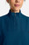 The HH752 Quest Bella Women’s Partial Zip Stand Collar Top is shown in a close‑up view emphasizing its Caribbean Blue short‑sleeve construction, smooth partial‑zip collar, and practical chest pocket holding a pen. The clean, professional detailing reinforces its purpose as a dependable uniform top for healthcare, hospitality, and other active roles.