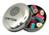 A metal tin containing colourful rock candy pieces in pink and teal, with a logo on the lid.