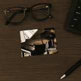 A promotional card featuring a grand piano and the Yamaha logo, placed on a wooden surface with glasses and a keyboard nearby. A promotional card featuring a grand piano and the Yamaha logo, placed on a wooden surface with glasses and a keyboard nearby.