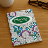 An A4 colouring book with intricate floral designs in purple, blue, and green on a white cover, featuring a logo. An A4 colouring book with intricate floral designs in purple, blue, and green on a white cover, featuring a logo.