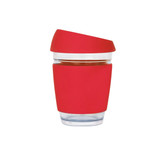 A reusable glass coffee cup featuring a red silicone sleeve and lid, with a transparent glass body.