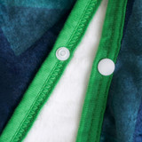 A flannel blanket featuring a green edge with buttons, showcasing soft textures in shades of blue and white.
