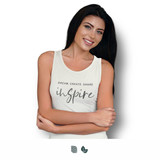 A woman models a white tank top with a logo, featuring the words "Dream, Create, Share, Inspire".