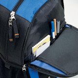 A black backpack with blue accents containing pens, markers, and a notepad in an open pocket.