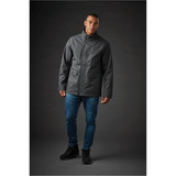 A men's Montauk System jacket in dark grey, featuring a high collar and front pockets, worn with blue jeans.