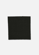 A square swatch of dark green wool fabric with a textured finish and a scalloped edge. It features a branding logo.