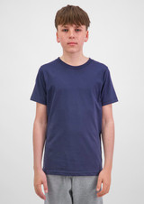 A youth short sleeve tee in navy blue, displayed on a model standing against a plain background, with a logo visible.