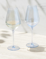 A set of two elegant blue-tinted wine glasses, one filled with white wine, presented on a light surface.