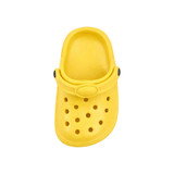 A yellow clog shoe fridge magnet with ventilation holes and a strap, featuring a logo.