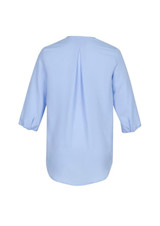 A light blue women's longline blouse featuring a back pleat and three-quarter sleeves. It has a logo visible.