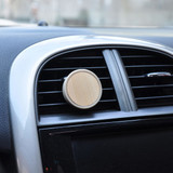 A car air freshener with a circular bamboo design, mounted on an air vent in a vehicle. A car air freshener with a circular bamboo design, mounted on an air vent in a vehicle.