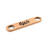 A bamboo bottle opener in a natural wood finish with a logo, featuring two circular holes for grip.