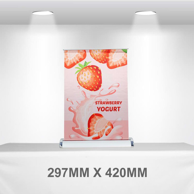 A pull-up banner featuring a pink design with strawberries and yogurt imagery. It includes a logo at the bottom. A pull-up banner featuring a pink design with strawberries and yogurt imagery. It includes a logo at the bottom.