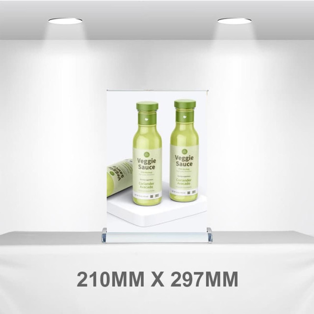 A pull-up banner displaying two green bottles of Veggie Sauce, set against a neutral background. A pull-up banner displaying two green bottles of Veggie Sauce, set against a neutral background.