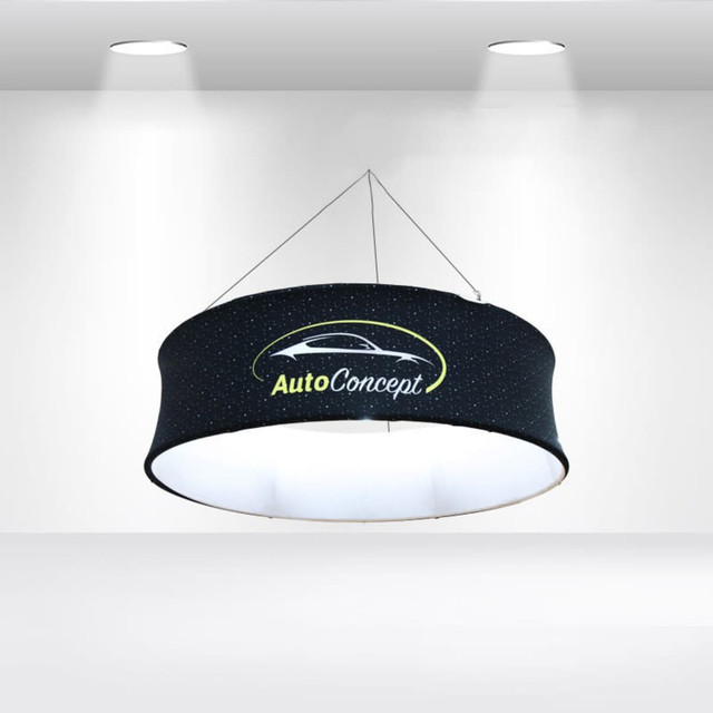 A round hanging banner in black with a logo, illuminated from within, featuring a starry design. A round hanging banner in black with a logo, illuminated from within, featuring a starry design.