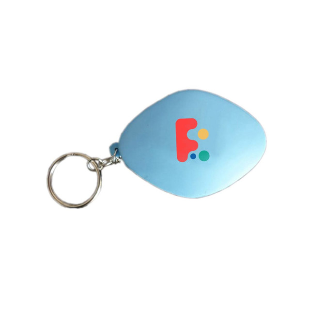 A blue tablet-shaped stress reliever keyring with a logo on one side, attached to a metal keychain.