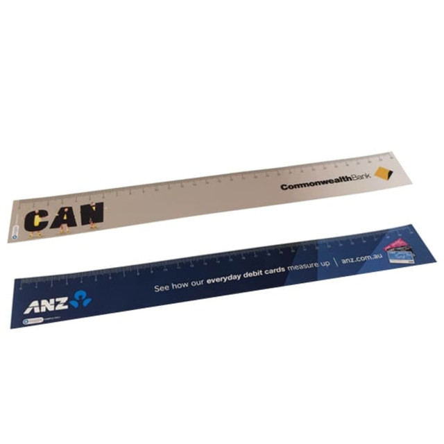 A set of two flexible synthetic rulers, one in beige with a logo, and one in blue with a logo. Each measures 15 cm. A set of two flexible synthetic rulers, one in beige with a logo, and one in blue with a logo. Each measures 15 cm.