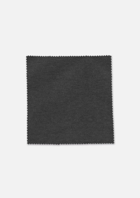 A swatch of dark grey fabric with a textured finish, featuring a zigzag edge. It has a branding logo.
