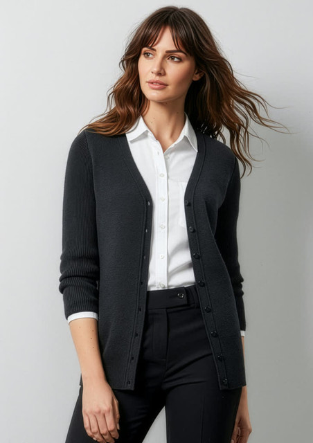 A woman models a dark grey cardigan, featuring a button front and ribbed cuffs, paired with a white shirt and black trousers.