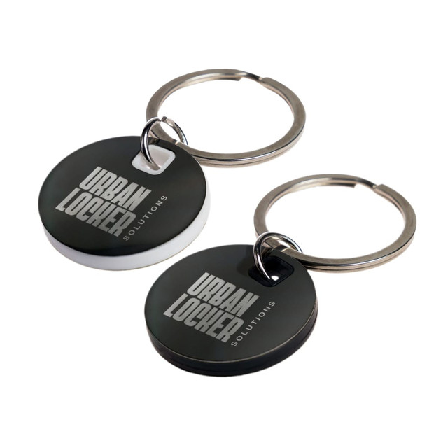 A circular stainless steel keytag in black and white with a metal keyring. Features a logo on the surface.
