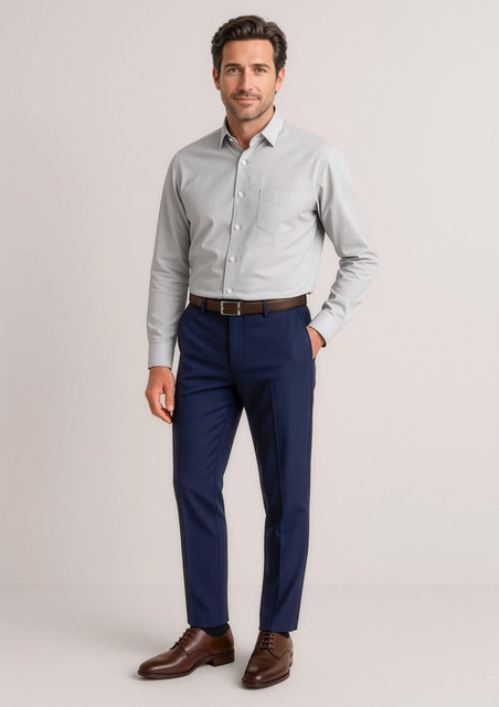 A man wearing a grey shirt and navy slim fit flat front pants, complemented by brown shoes and a belt.