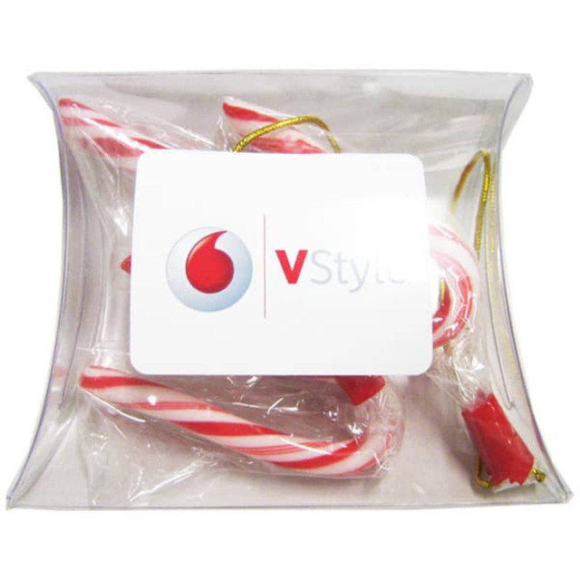 A clear pillow pack containing red and white striped candy canes, featuring a branding logo on the front.