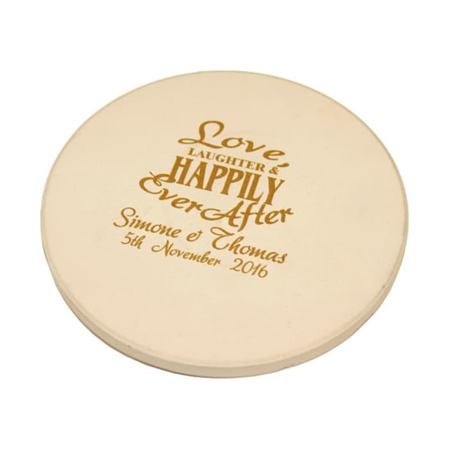 A round, beige absorbent stone coaster featuring engraved decorative text and a branding logo.