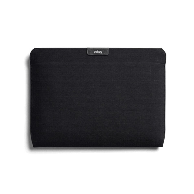 A black laptop sleeve featuring a logo, designed to fit a 16-inch laptop.