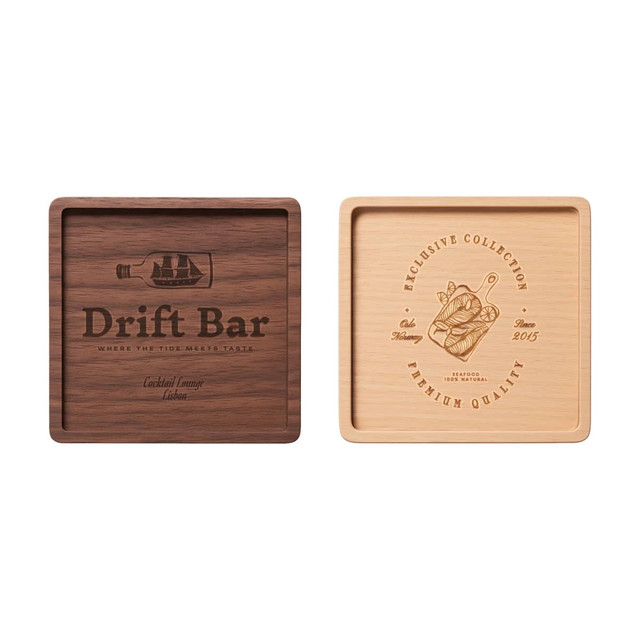 A square wooden coaster featuring a dark wood and a light wood side, each with unique engravings, including a logo.