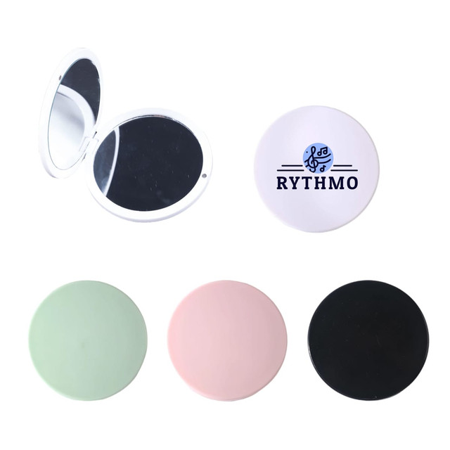 A double-sided round mirror featuring four colour options: green, pink, black, and white with a branding logo.