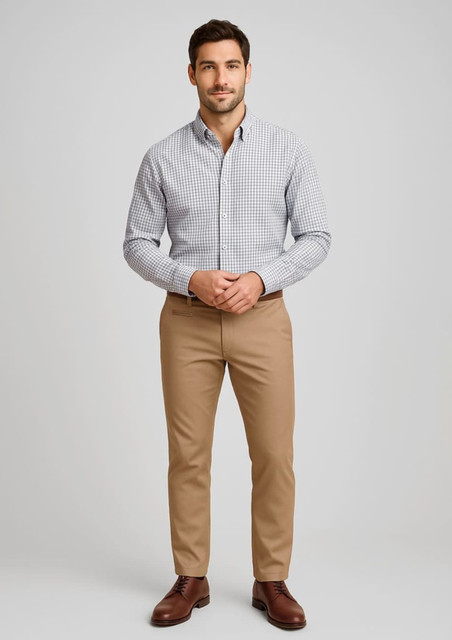 A man in a checkered shirt and tan stretch chino pants, standing with hands clasped in front. The outfit includes brown shoes.