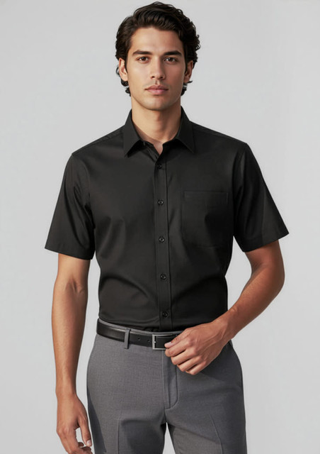 A short-sleeve button-up shirt in black, featuring a pocket, worn with tailored grey trousers.