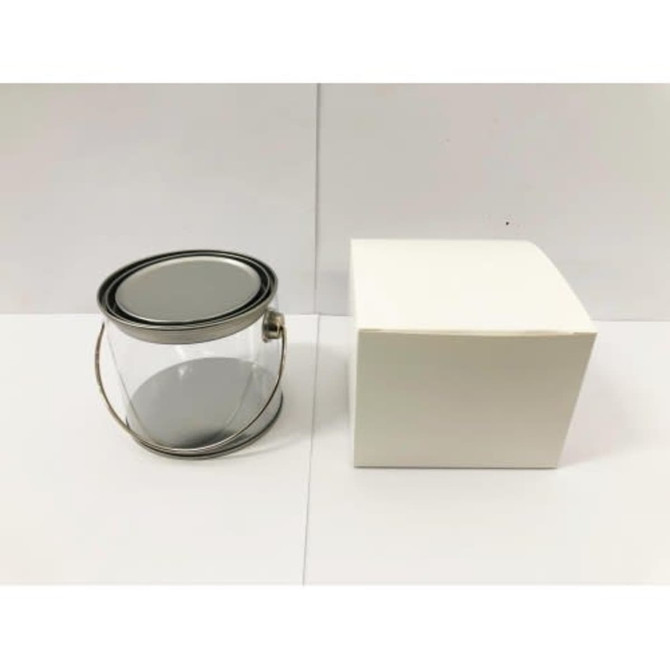 A medium clear PVC bucket with a metal handle next to a plain white box.