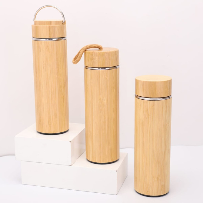 A drink bottle trio in natural bamboo finish, featuring metal accents and various styles, displayed on a white platform.