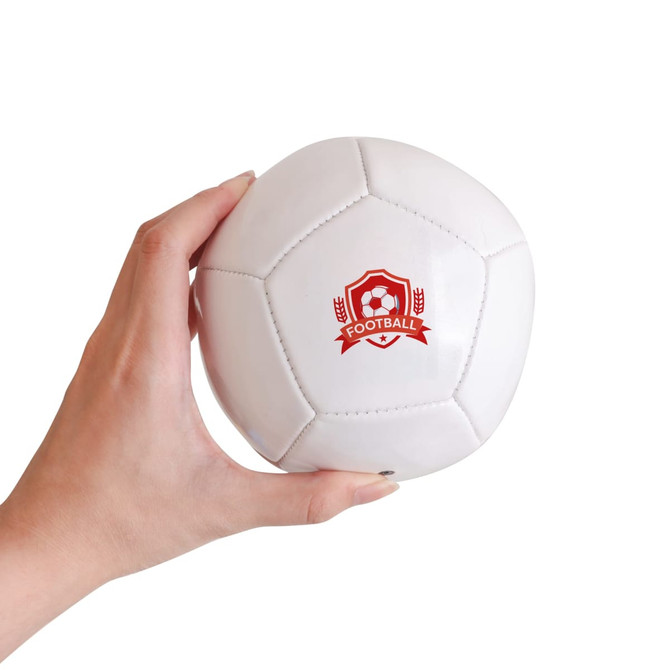 A mini white soccer ball held in a hand, featuring a logo on one side.