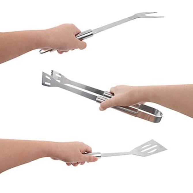 Three pieces of stainless steel barbecue tools held in hands, including a fork, spatula, and tongs, with a pouch present.