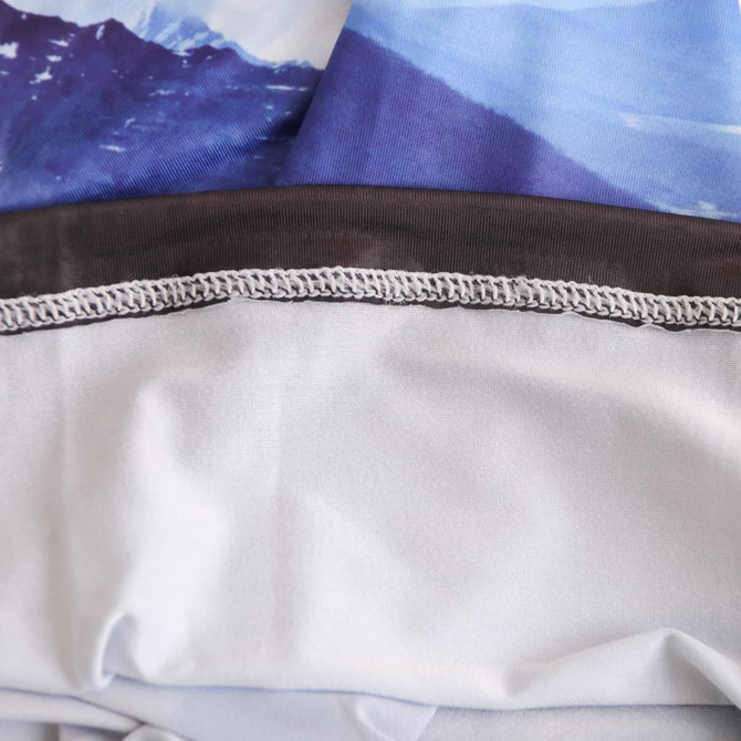 An Ice Silk Neck Gaiter featuring a mountain print in shades of blue and grey, with a smooth, elastic edge.