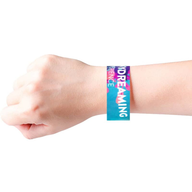 A disposable full-colour Tyvek wristband in turquoise and pink on a wrist, featuring a logo.
