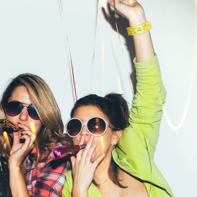 A vibrant yellow stretchy wristband is worn by a woman celebrating, while another woman poses with sunglasses.