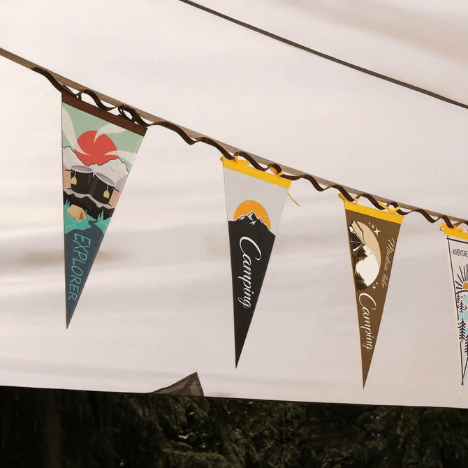 A set of colourful felt pennants with various outdoor designs, displayed on a string under a canopy.
